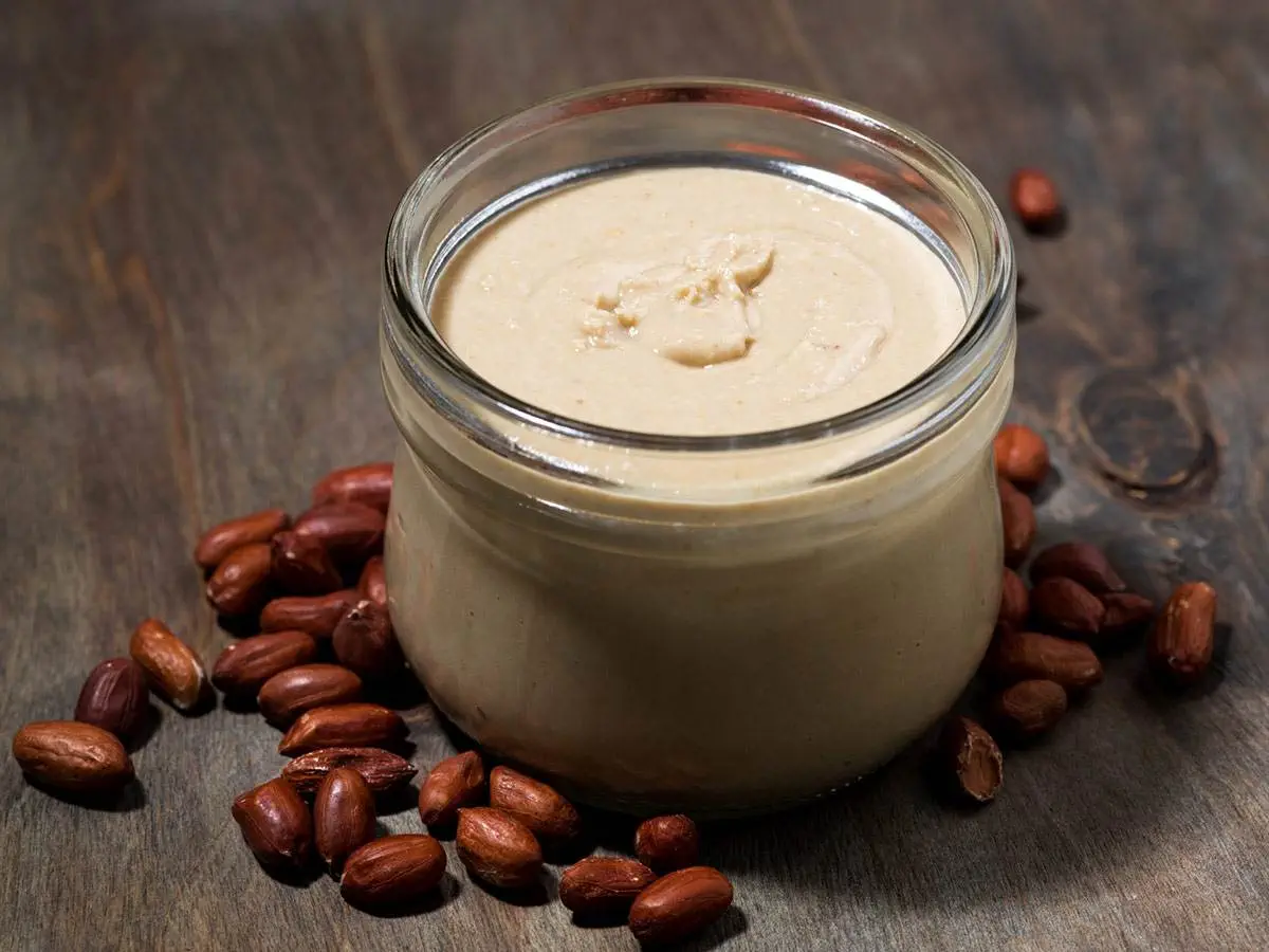 A jar of organic peanut butter with peanuts