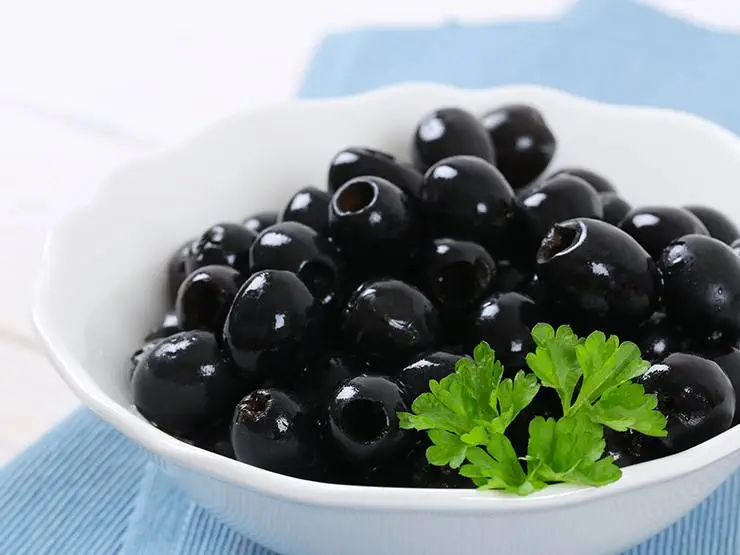 Fresh black olives in a white bowl