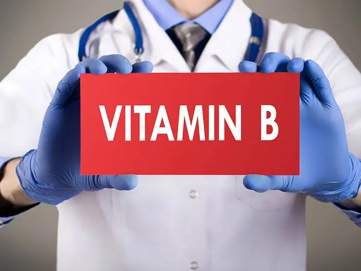 A vet holding a card with the text vitamin B