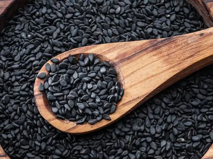 Black sesame seeds with wooden spoon