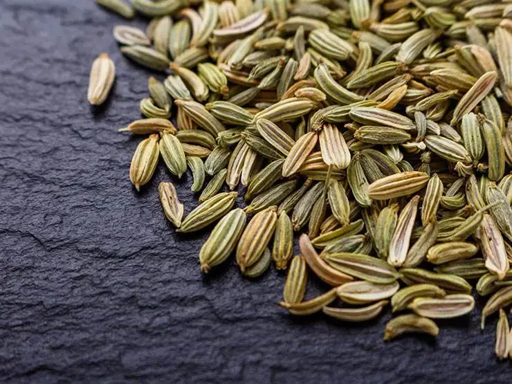 Dry fennel seeds on a black table