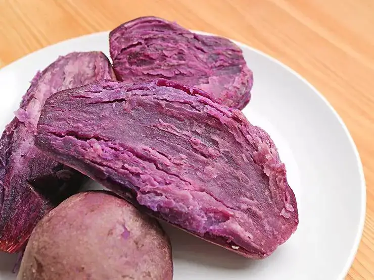 Purple steamed sweet potatoes on a plate